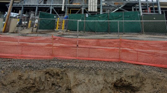 Microgrid power project under construction, with an excavation in the foreground exposing underground cables